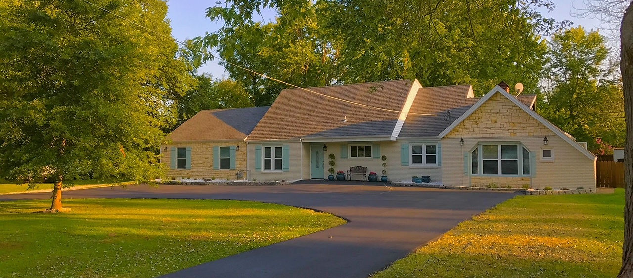 Exterior view of Close to Paradise Assisted Living Facility, featuring a beautifully landscaped garden with vibrant flowers, lush greenery, and walking paths for residents. The modern, single-story building has a welcoming facade with large windows and a covered porch, offering a tranquil and serene environment for senior living. Designed for comfort and accessibility, this assisted living community provides a safe, home-like atmosphere for elderly care. Perfect for retirees looking for personalized support, social activities, and a peaceful lifestyle surrounded by nature. Keywords: Close to Paradise, assisted living, senior care facility, elderly support, retirement community.