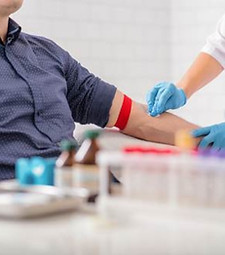 Phlebotomy student preparing an arm for blood draw.