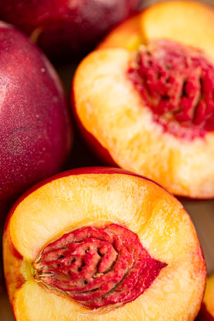 Plusieurs pêches coupées, composition gourmande, textures et couleurs chaudes.