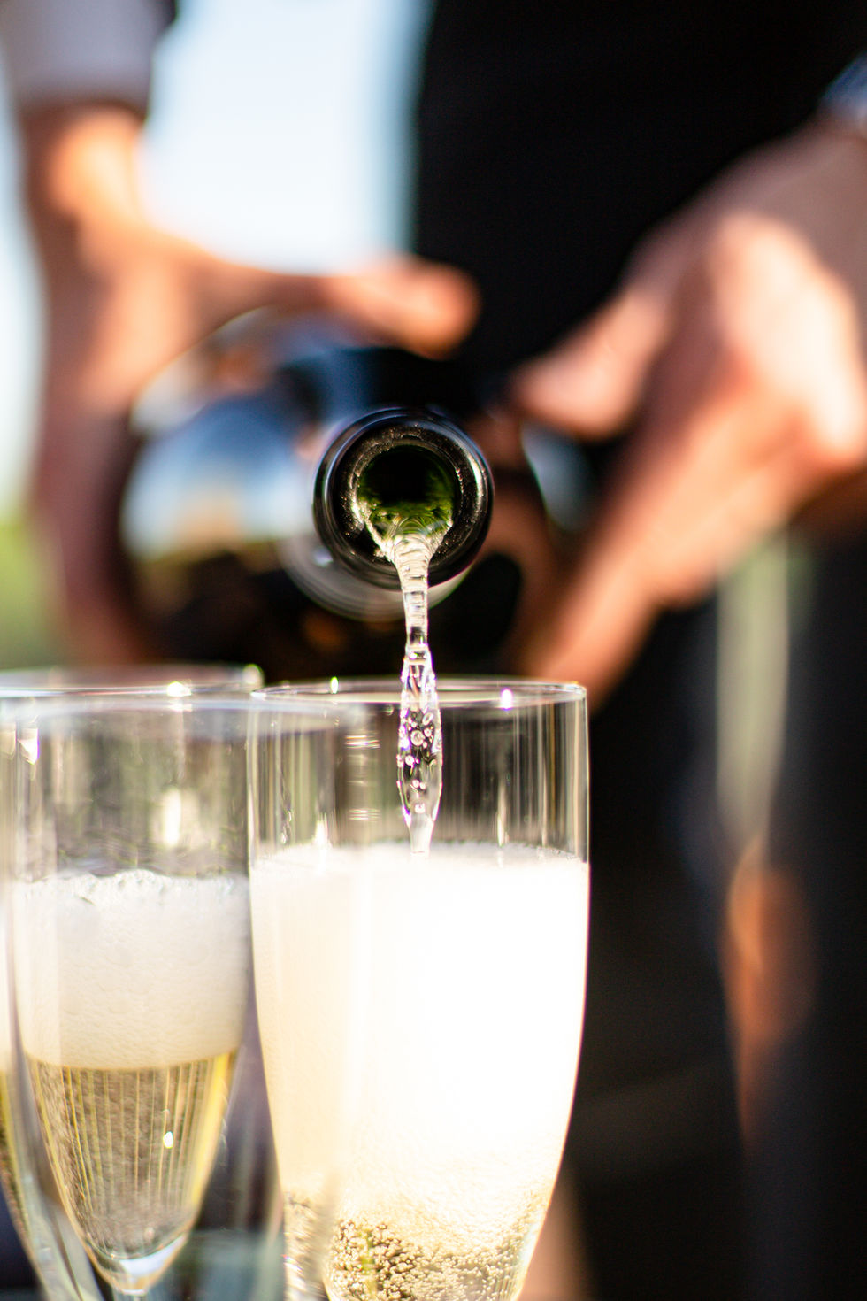 Champagne versé dans les flûtes, moment convivial à Ostara Ecolodge