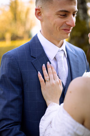 Portrait du marié en costume bleu, sourire discret, lumière de fin de journée.