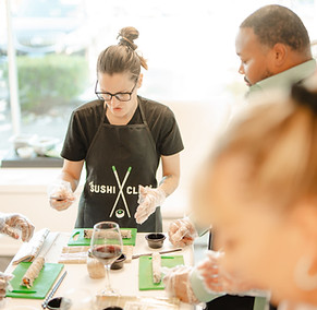 Team rolling sushi together during a company bonding session