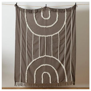 Grey throw blanket with white arch pattern hanging on wall