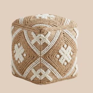 Square jute pouf with thick white embroidered cross and diamond motifs.