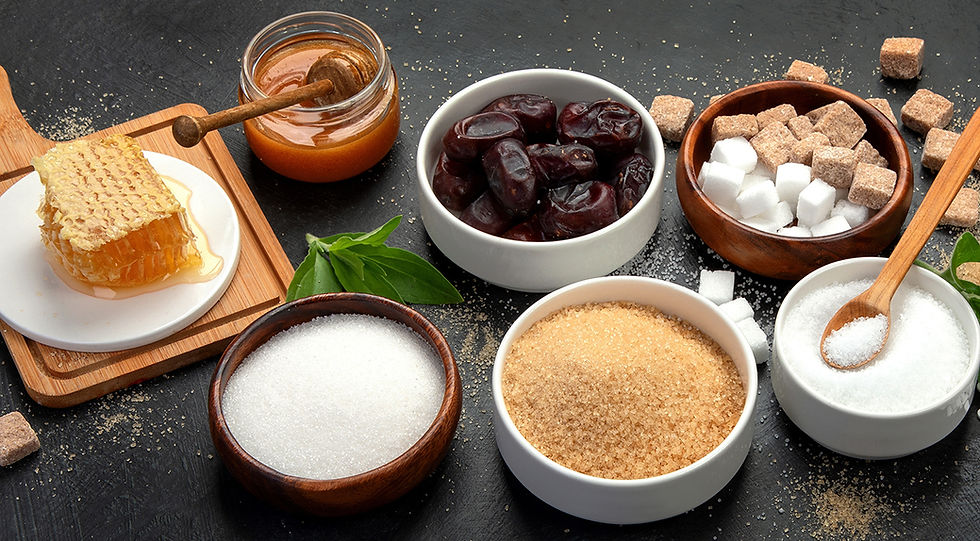Various sugars displayed: honeycomb, jar of honey, dates, white and brown sugar cubes, granulated sugar in bowls.