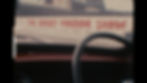 The steering wheel of a car is shown in front of a screen with The Rocky Horror Show written in dripping blood type.
