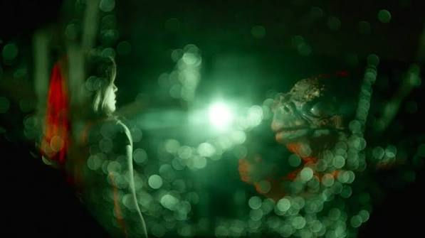 A blurry screen with a white woman staring at a large frog creature