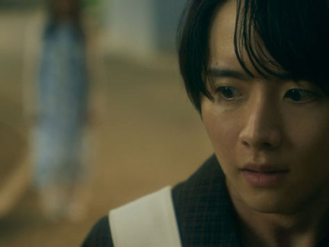 A Japanese man with dark floppy hair looks terrified as he looks to the side.