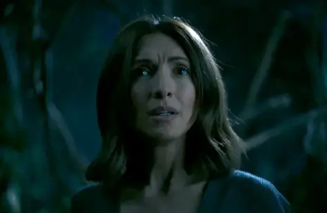 A white woman with shoulder length brown hair is looking concerned