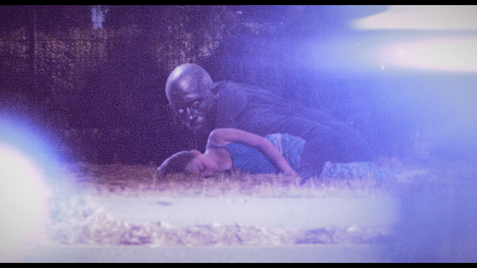 A dark figure is leaning over an unconscious child