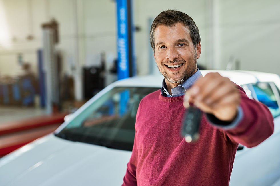 satisfied-male-customer-holding-car-key-auto-repair-shop-looking-camera.jpg