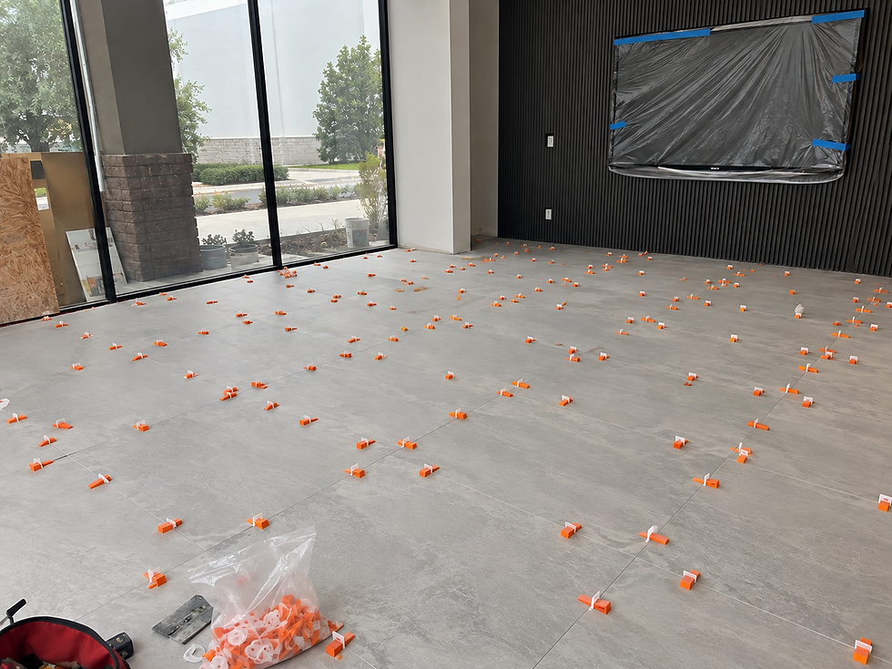 Flooring Contractor Miami installing large tile floor with leveling spacers.