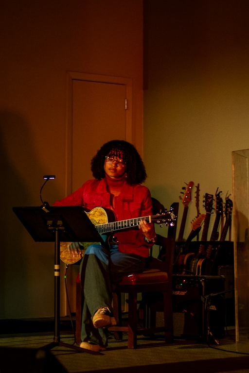 Photo of girl playing guitar at a concert