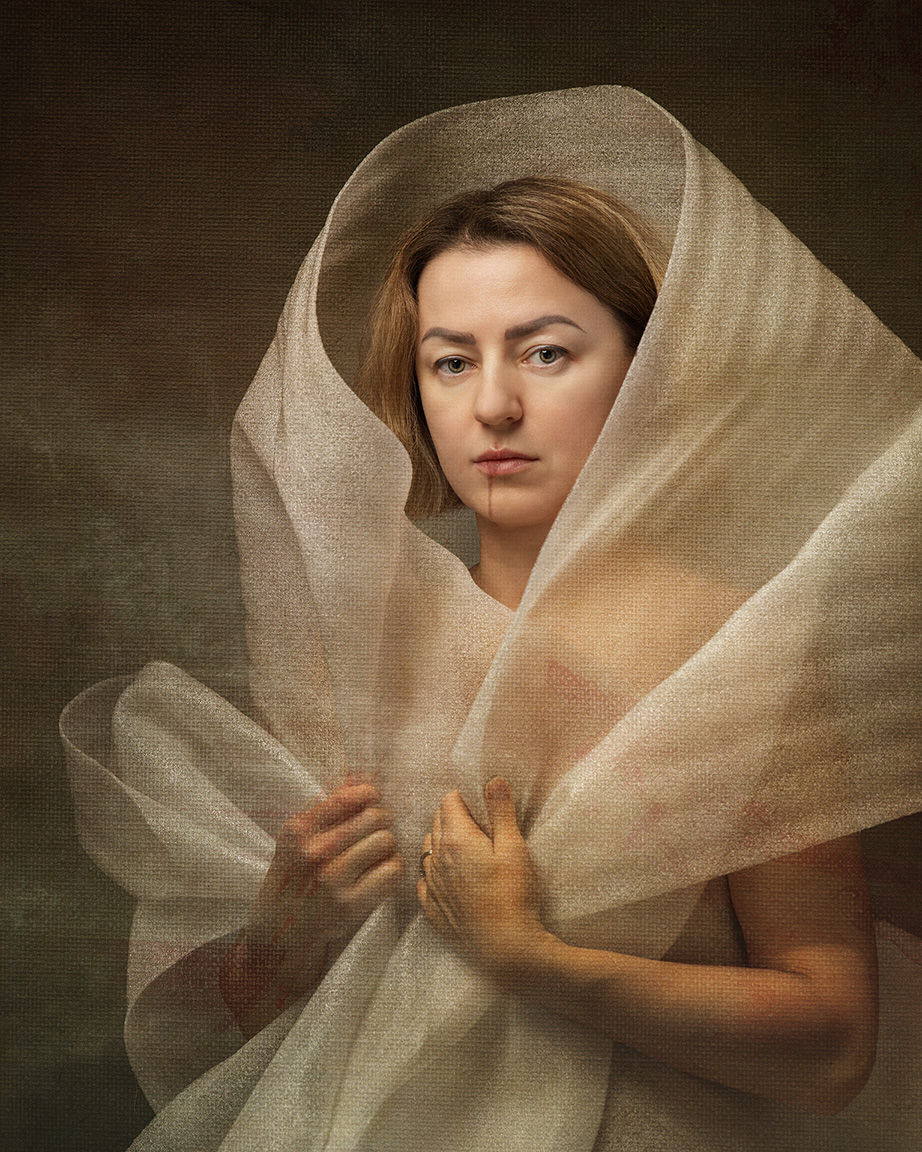 Self-portrait where hands draw translucent fabric inward across the torso, tightening the wrapping.