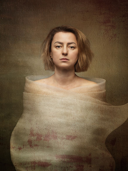 Self-portrait with translucent fabric wrapped densely around the torso, forming a contained shape; upright posture and steady expression suggest subtle fatigue and internal saturation.