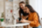 Two women at a computer analyzing personal loan performance