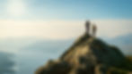 Two hikers standing on a mountain peak