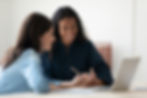 Two women discussing alternative assets at a computer