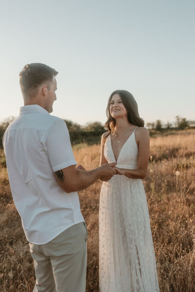 Happy couple holding hands in field