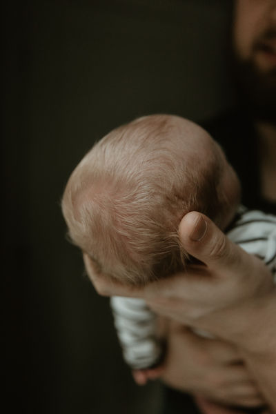 Close-up of newborn baby's head in parent's hands