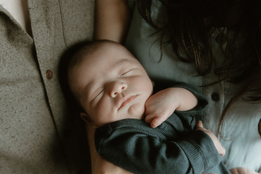 Peaceful newborn sleeping soundly in mother's arms