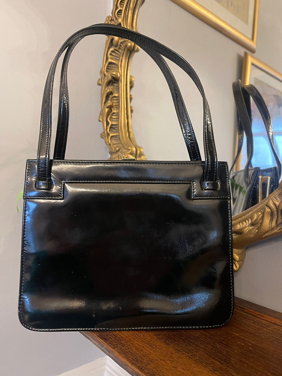 Thumbnail: black patent frame handbag by Hamilton hanging rear view on shelf