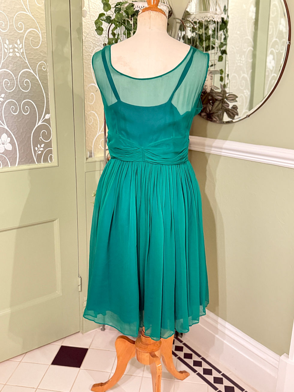 Thumbnail: Emerald green chiffon cross bodice dress with strappy under bodice rear view on mannequin.