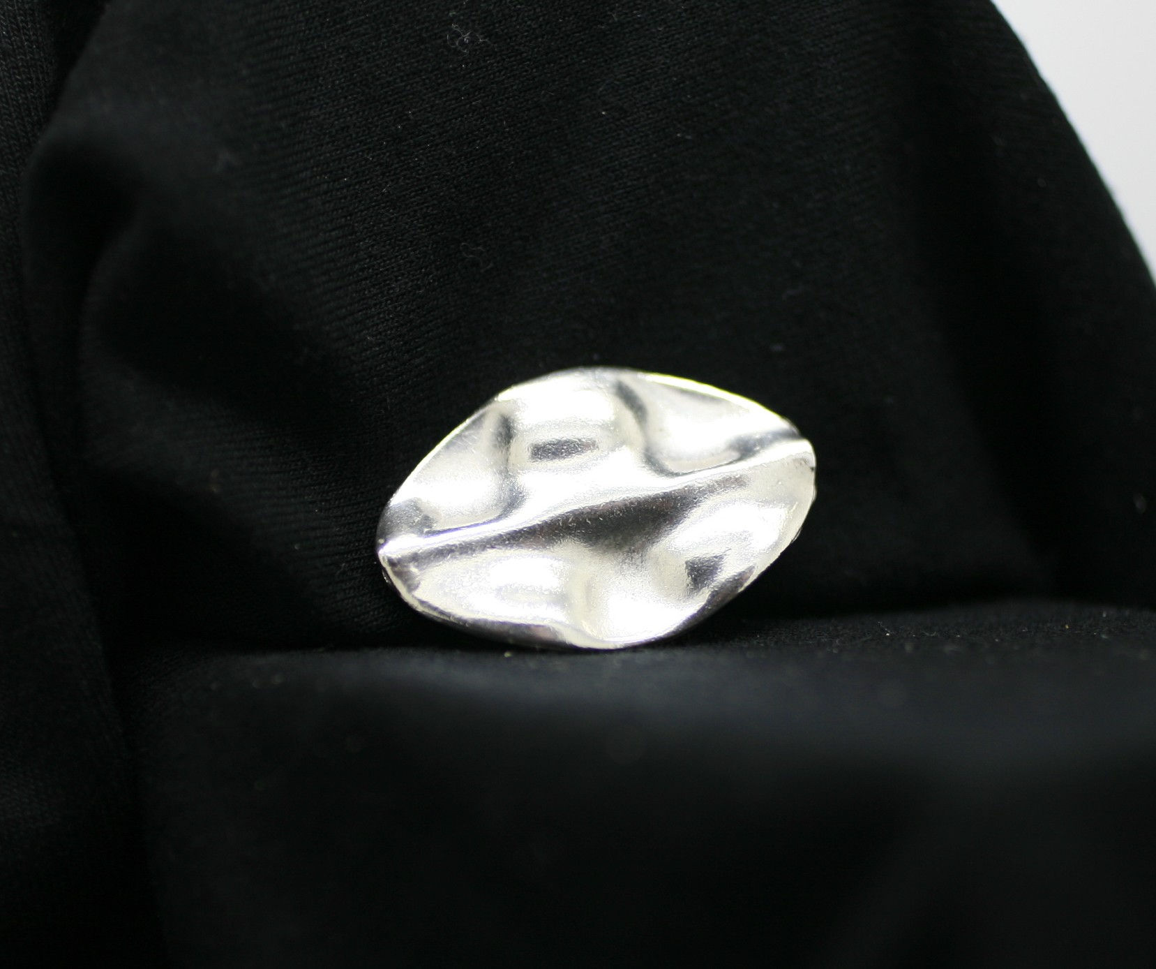 Thai silver oval bead with an uneven surface and smooth surface texture