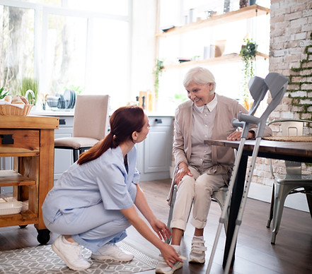 pensioner-smiling-while-caregiver-lacing-shoes-her.jpg