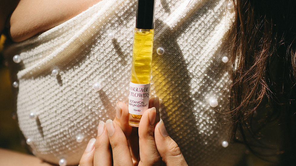 A woman gently holds a bottle of Rose and Co. natural perfume in up to her chest in a natural setting