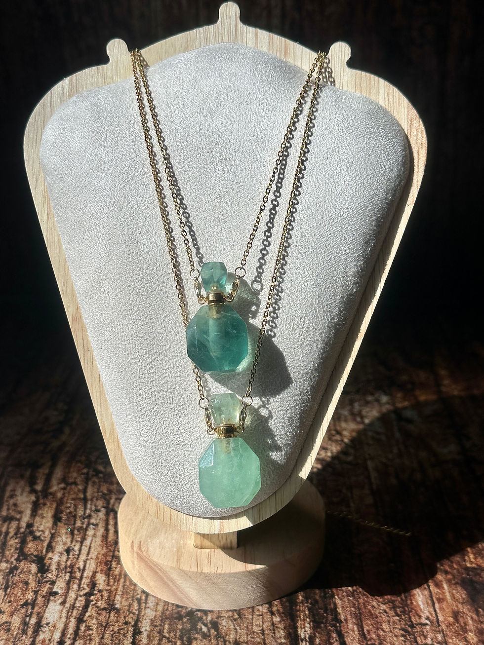 two green fluorite perfume pendants on a necklace stand