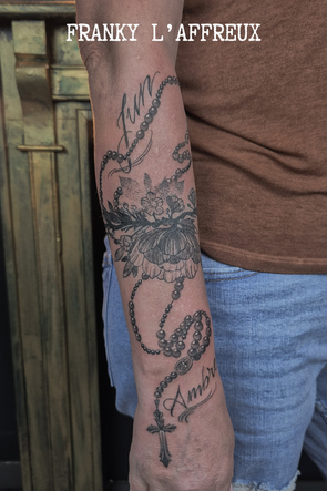 Tatouage style religieux d'un chapelet avec une fleur sur un avant-bras extérieur. Utilisé en cover. Réalisé par Franky l'affreux, gérant des Pluies d'avril