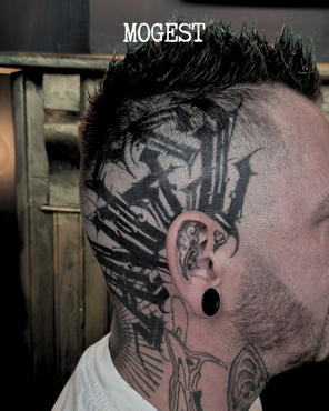 Tatouage dark / trash d'un lettrage "ANGEL" sur un côté de crâne, réalisé par Mogest, guest régulier aux Pluies d'avril