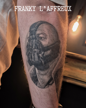 Tatouage de Bane, tiré des comics et du film Batman Rise, sur un avant-bras extérieur, réalisé par Franky l'affreux, gérant des Pluies d'avril