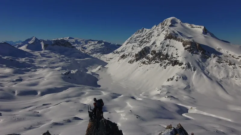 Séjour ski à Val d’Isère : deux randonneurs sur une arête rocheuse, face aux grands massifs enneigés