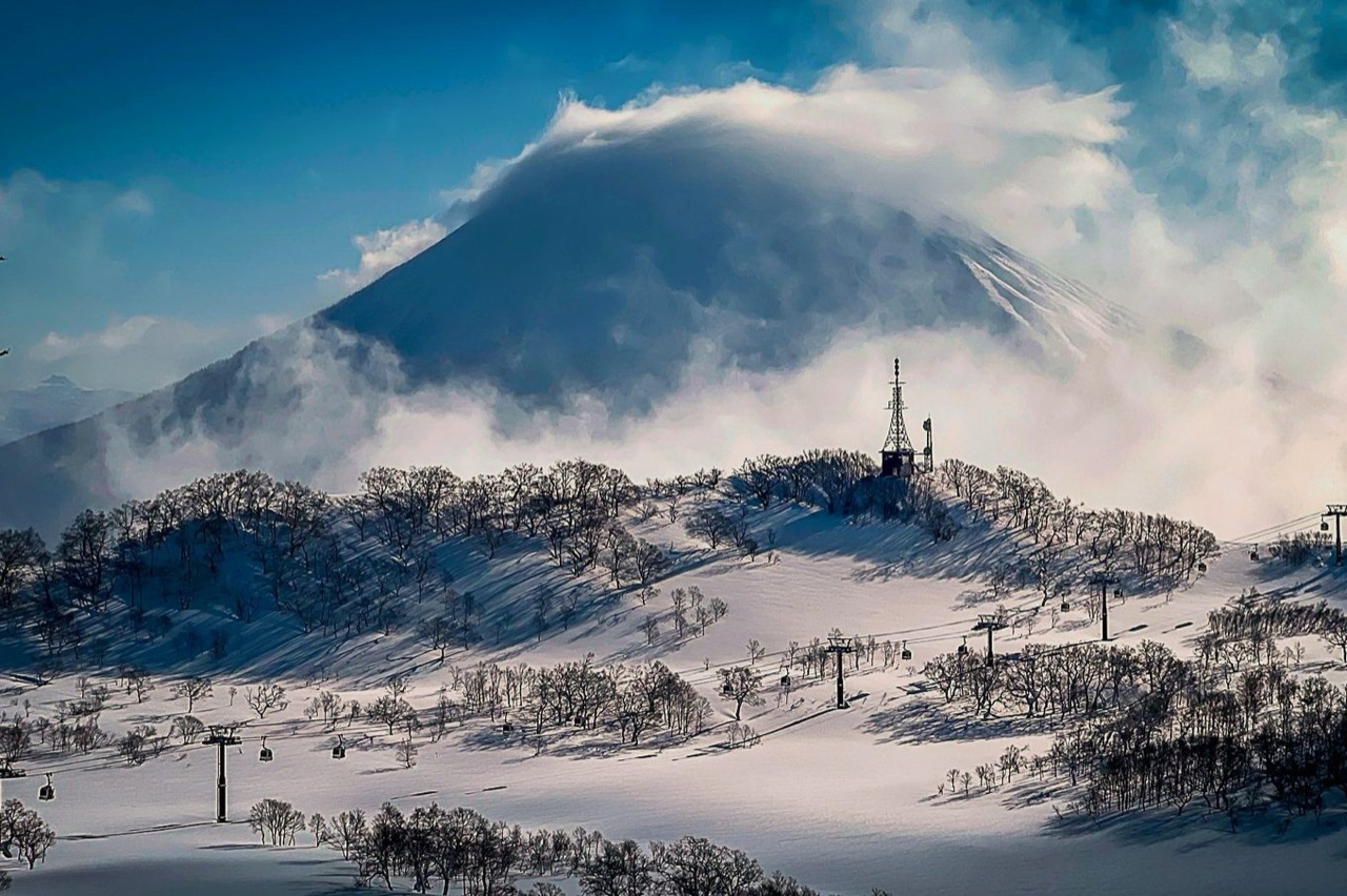 Mount Yotei, a cloud-capped volcanic cone rising above Niseko's wooded slopes