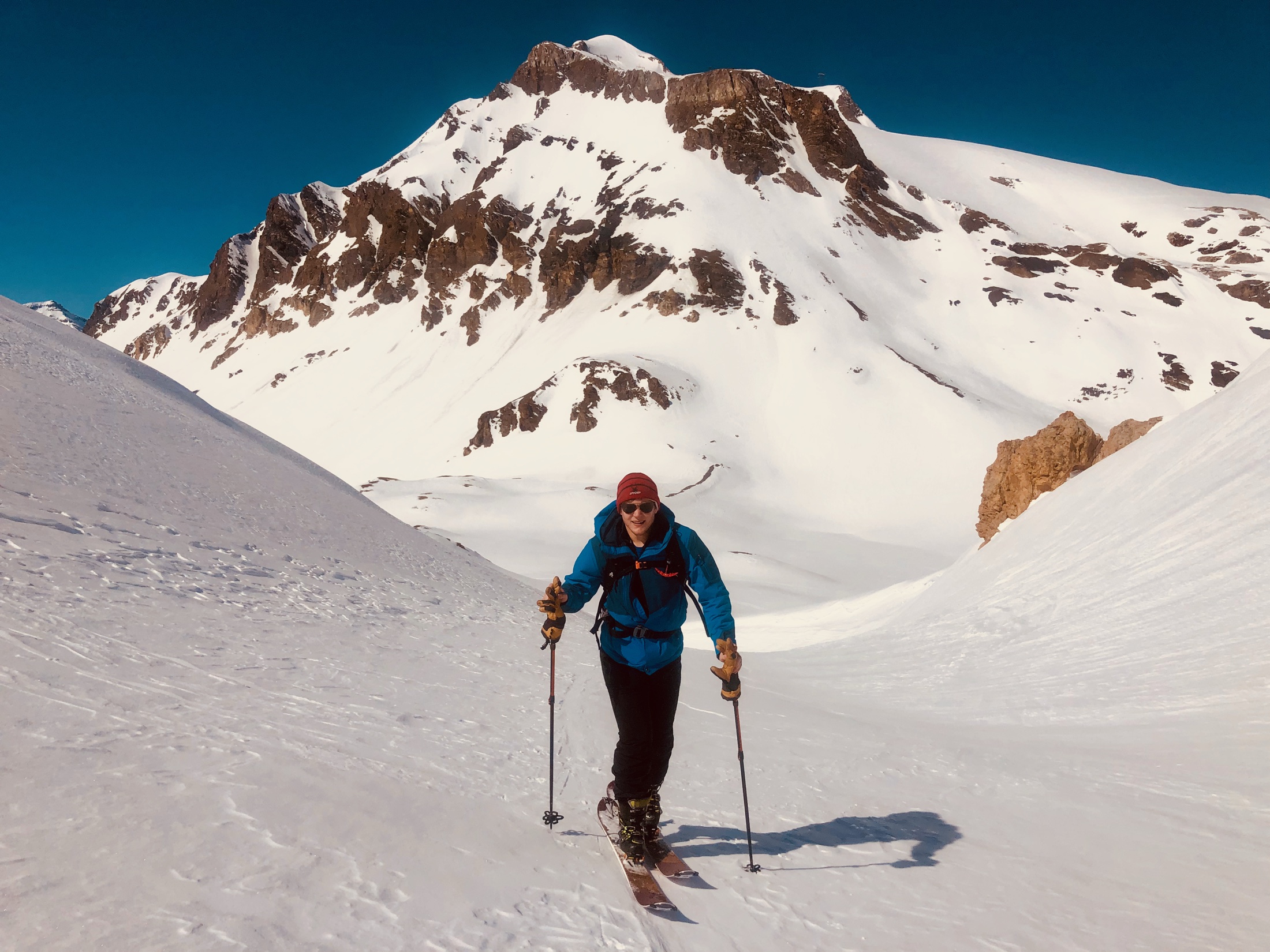 Skitourengeher steigen mit großem Abstand im Fellaufstieg einen verschneiten Rücken hinauf