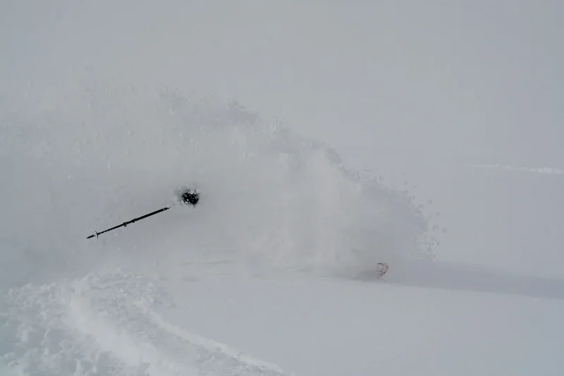 Ein Skifahrer in einer Wolke aus Pulverschnee, Hokkaido