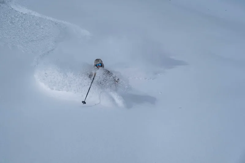 Eine Pulverschneefahne hinter einem Skifahrer, Hokkaido