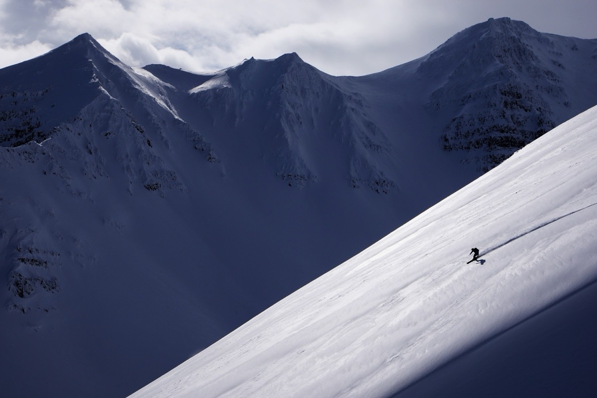 Skieur sur une grande face de neige raide du Tröllaskagi, du couloir à la face ouverte, ski de randonnée en Islande