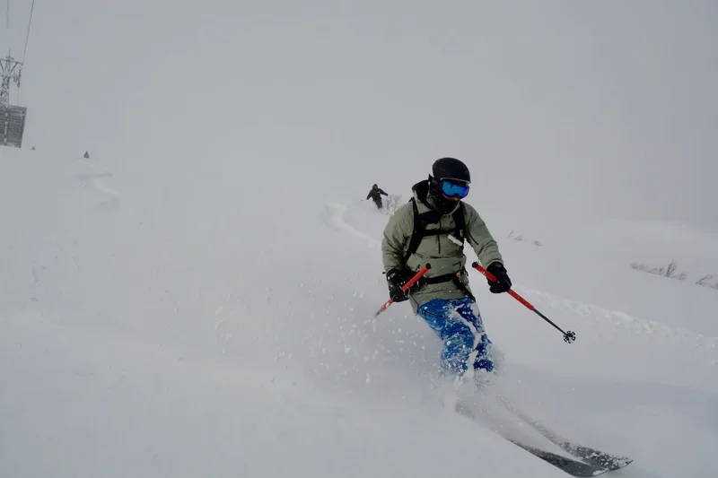 Ein Skifahrer mitten in der Abfahrt durch frischen Schnee