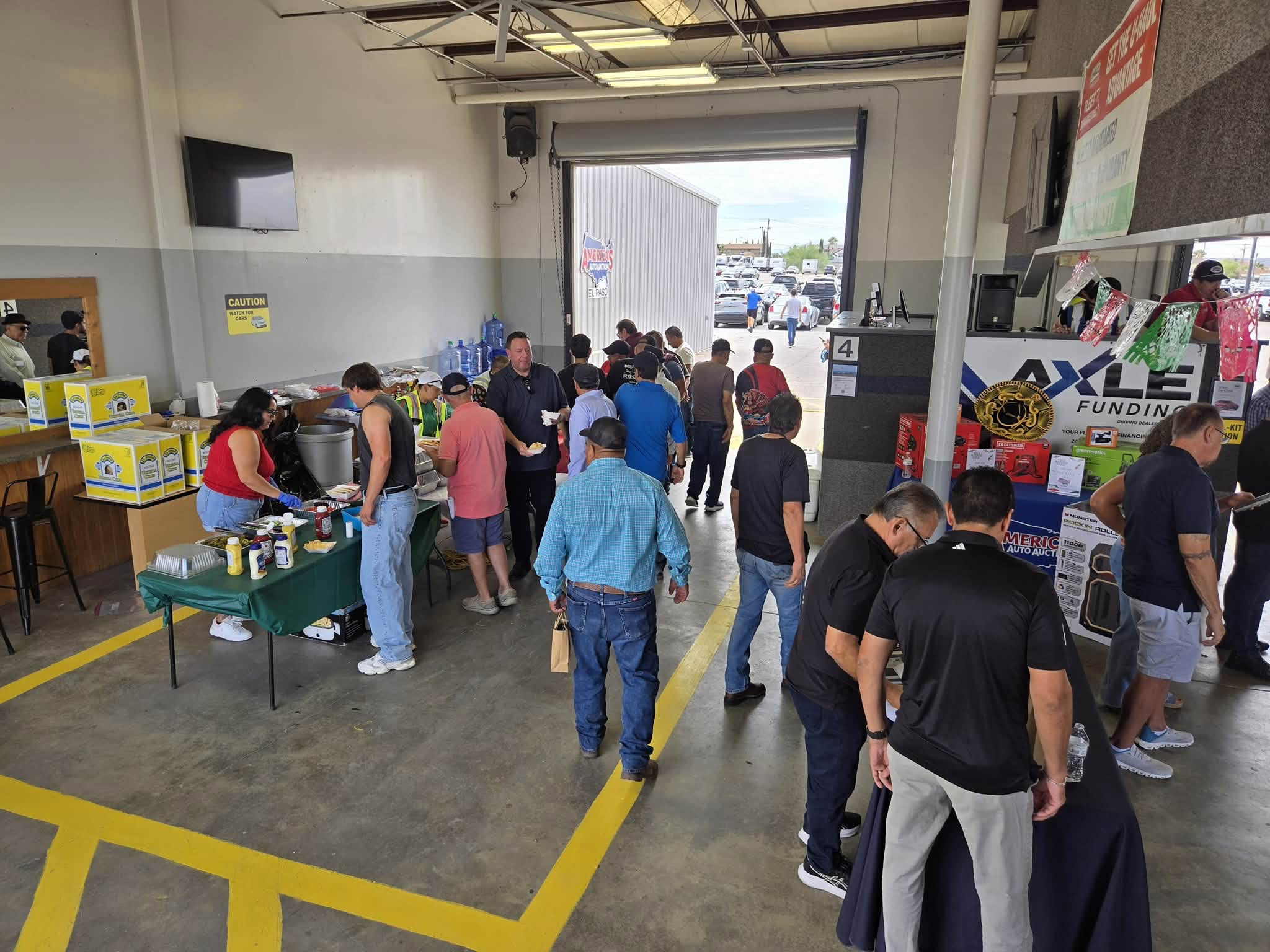 Dealers and community members gathering at an automotive auction facility.
