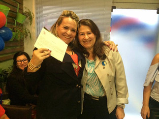 Two women smiling, holding a certificate