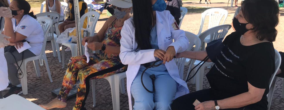 Doctor checking patient's blood pressure outdoors