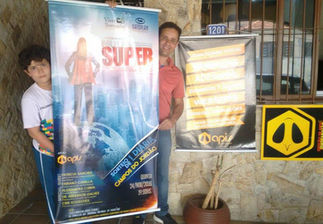 Two men holding movie posters: "Super" and another.