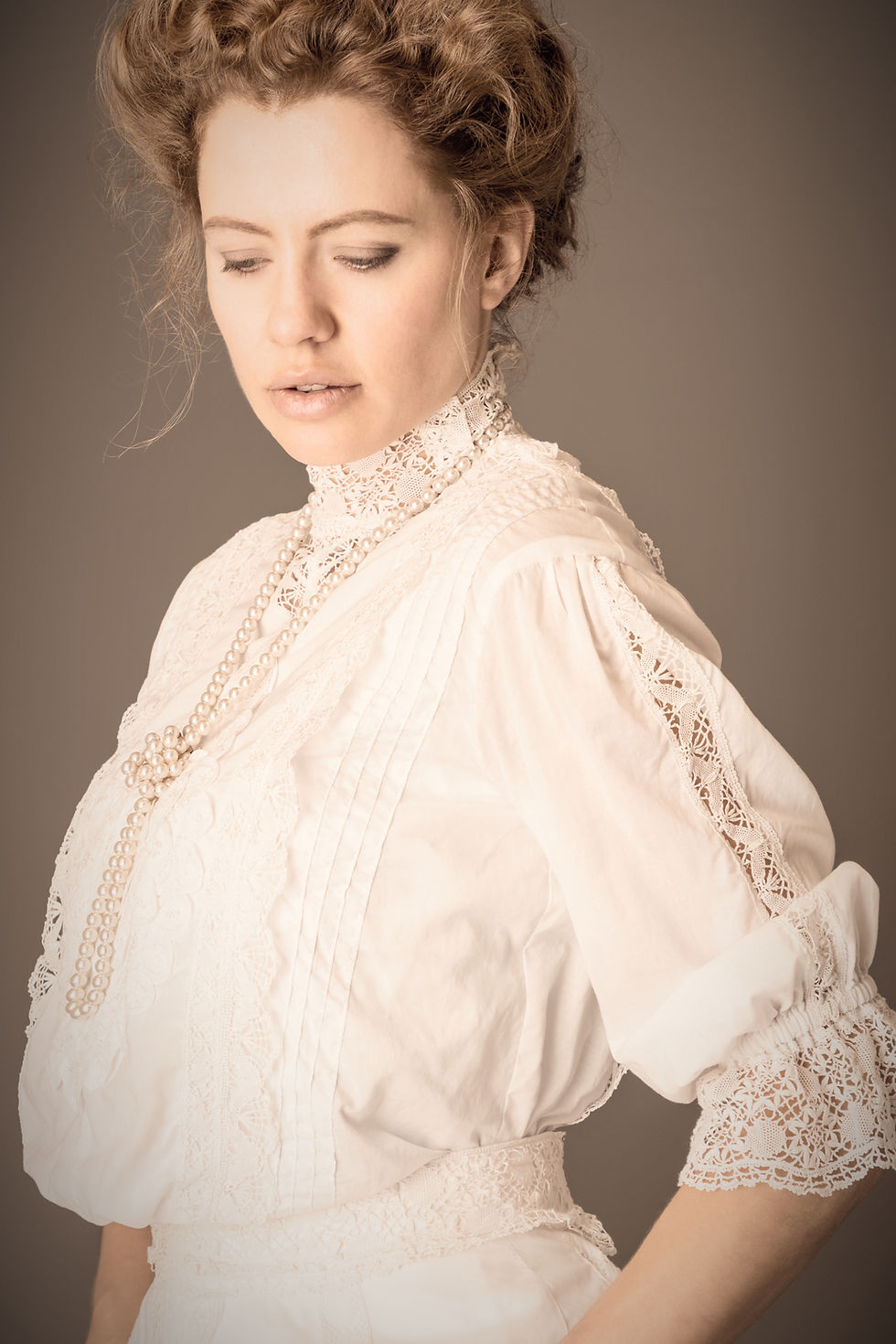 An Edwardian woman wearing a white lace blouse and skirt .jpg