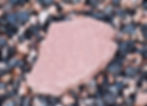 A smooth piece of red flagstone, sitting on multicolored gravel
