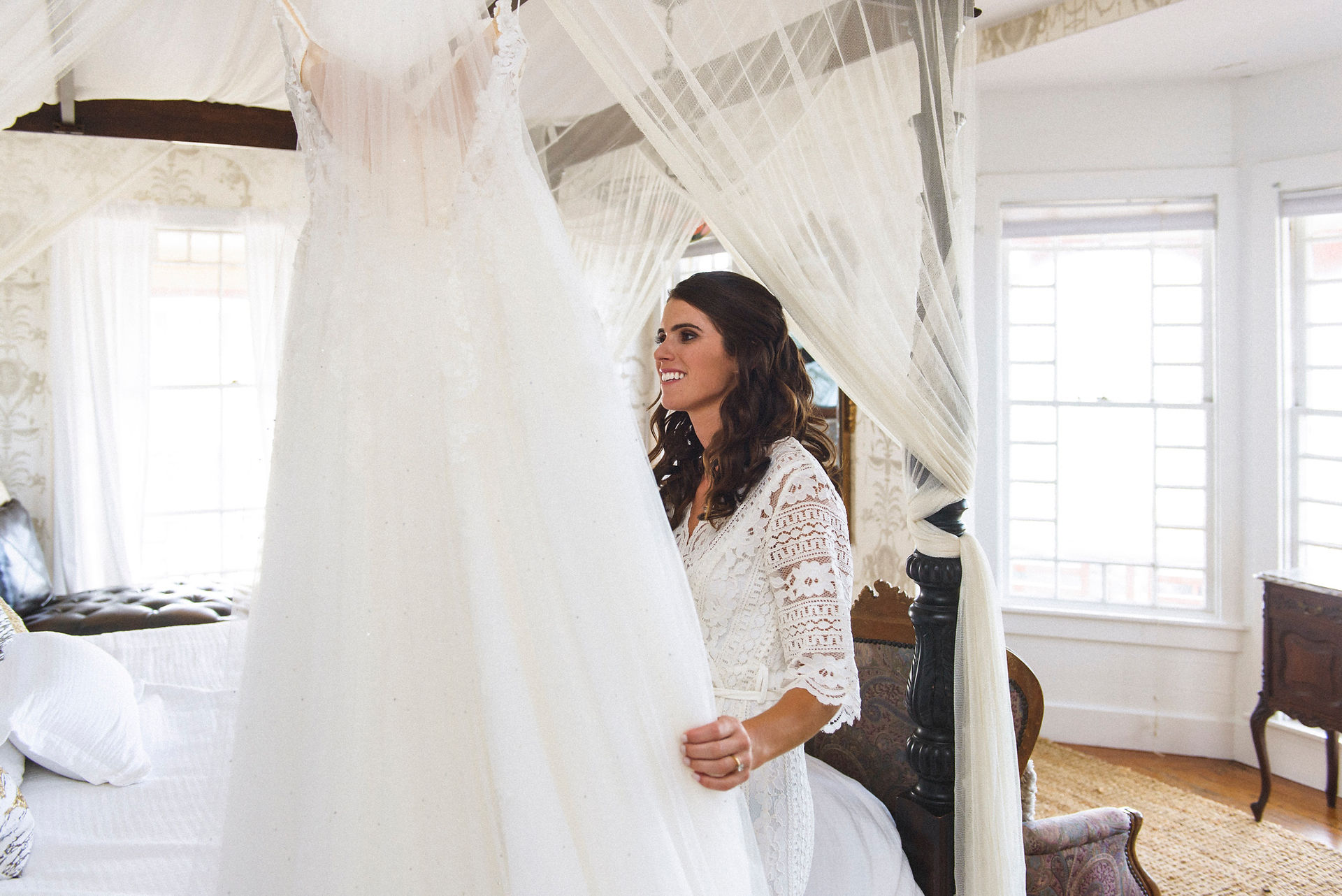 A bride takes a look at her hanging wedding dress photo by David Welch Photography