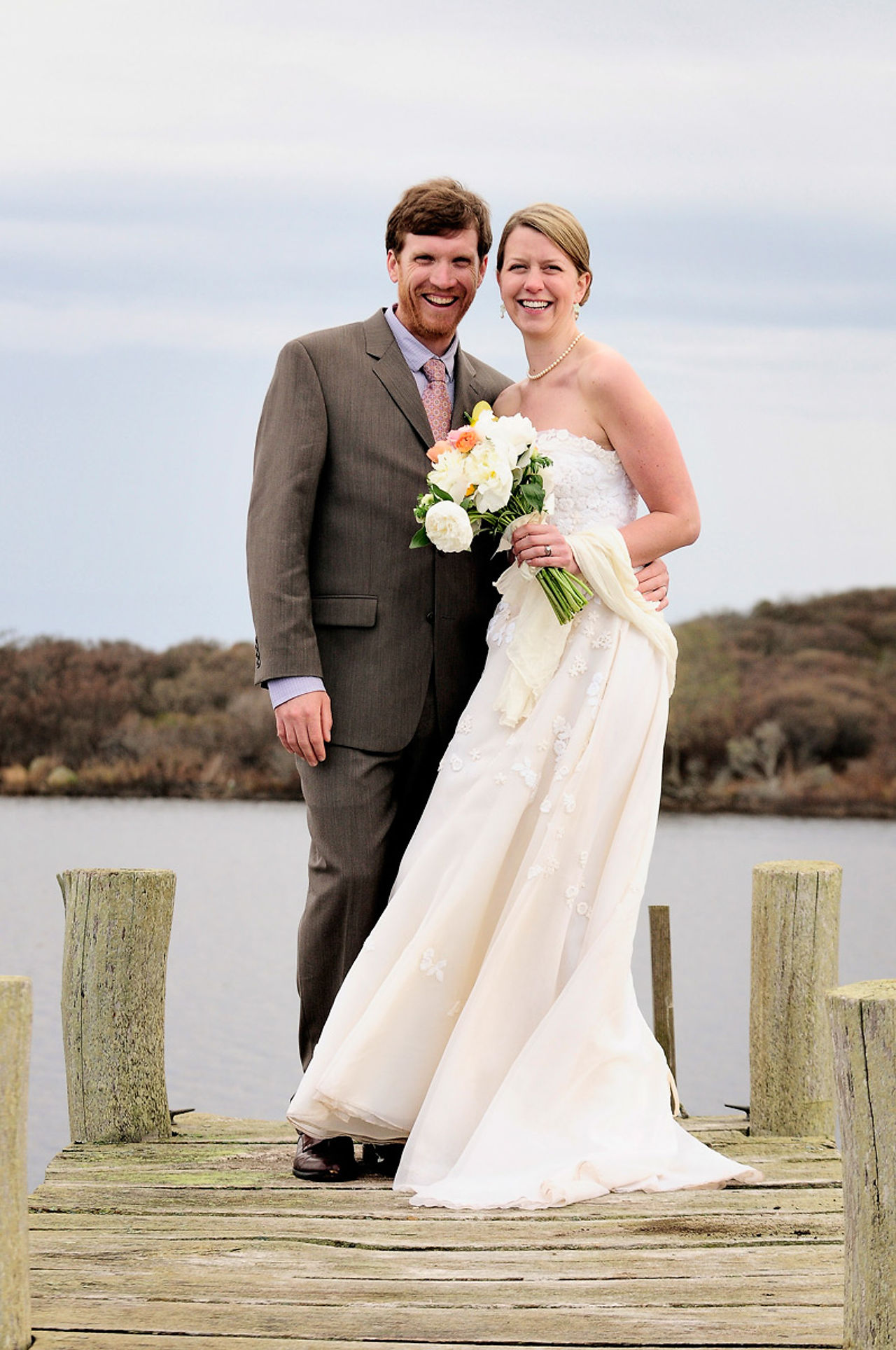 A bride and groom stand on a small pier near the Allen Sheep Farm in Chilmark photo by David Welch Photography