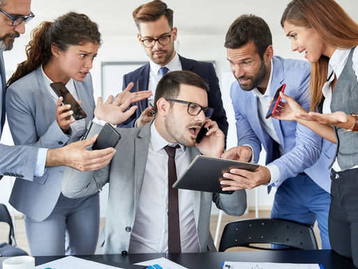 Ein Team im hektischen Meeting rund um den gestressten Teamleiter